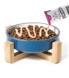 comedero de color azul repleto de comida seco para gato recibiendo crema de zen para gato.