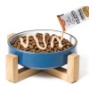 comedero de color azul repleto de comida seco para gato recibiendo crema de zen para gato.