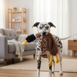 Perro jugando con pato de peluche acolchado.