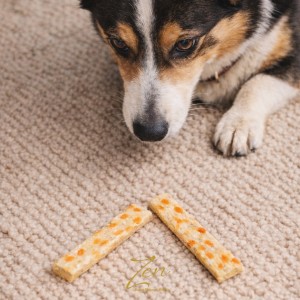Perro oliendo snack de colágeno para perro